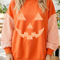 Orange sweatshirt with plaid pumpkin face graphic, long checkered sleeves