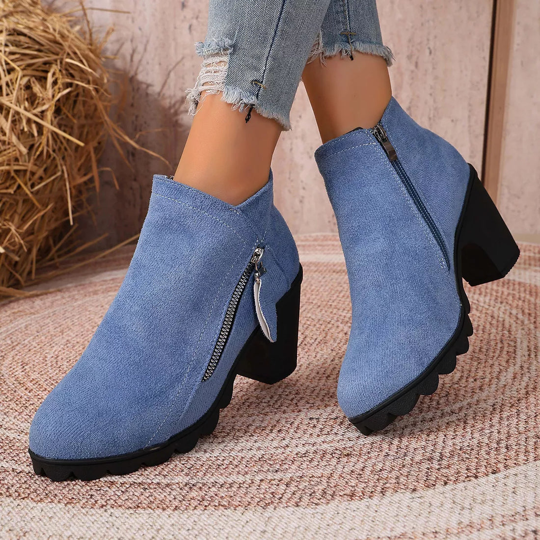 Pair of blue suede ankle boots with block heel and side zipper on round toe
