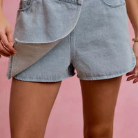 Light blue denim wrap skort with asymmetrical front overlay and side pockets