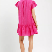 Back view of fuchsia textured mini dress with flutter cap sleeves and ruffle hem
