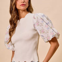 White ribbed knit sweater top with floral contrast puff sleeves and scalloped hem