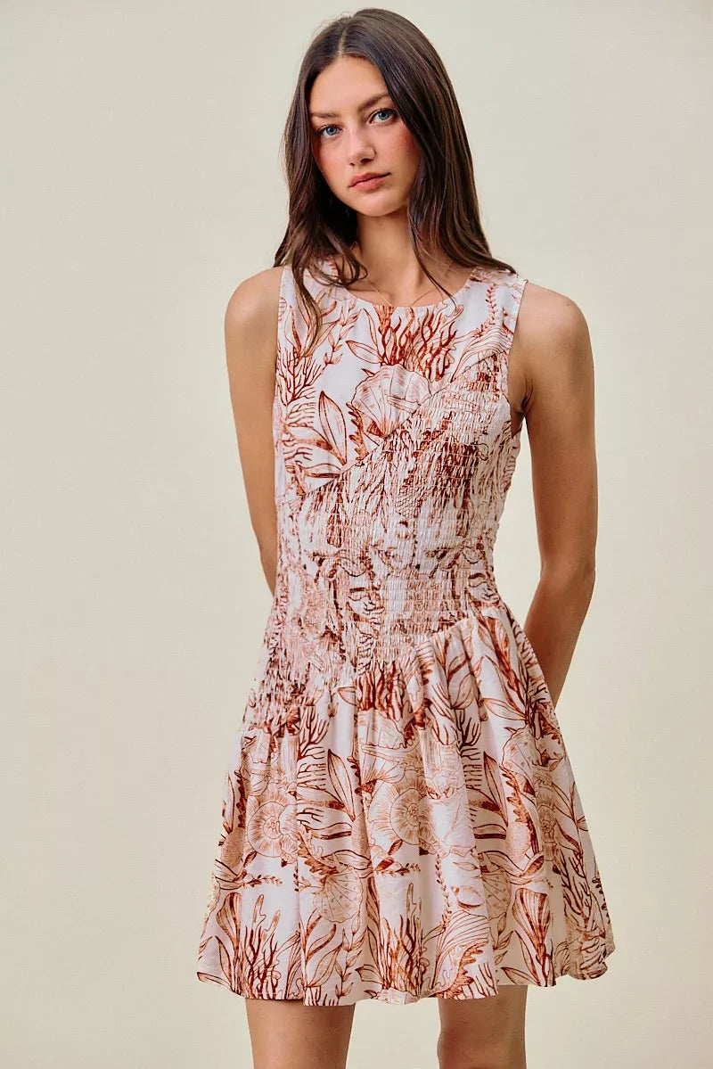 Coral and white shell print sleeveless mini dress with smocked bodice and flared skirt