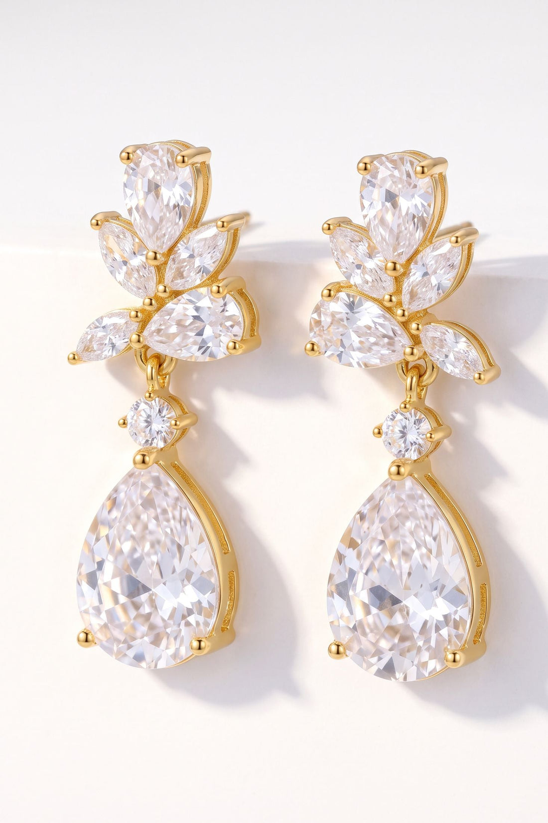 Gold-tone CZ teardrop drop earrings with clustered pear stones and dangling charm