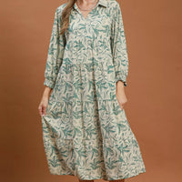Green linen botanical print tiered midi dress with gathered skirt tiers and long sleeves