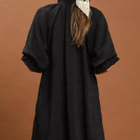 Black textured V-neck dress from back view with short flutter sleeves