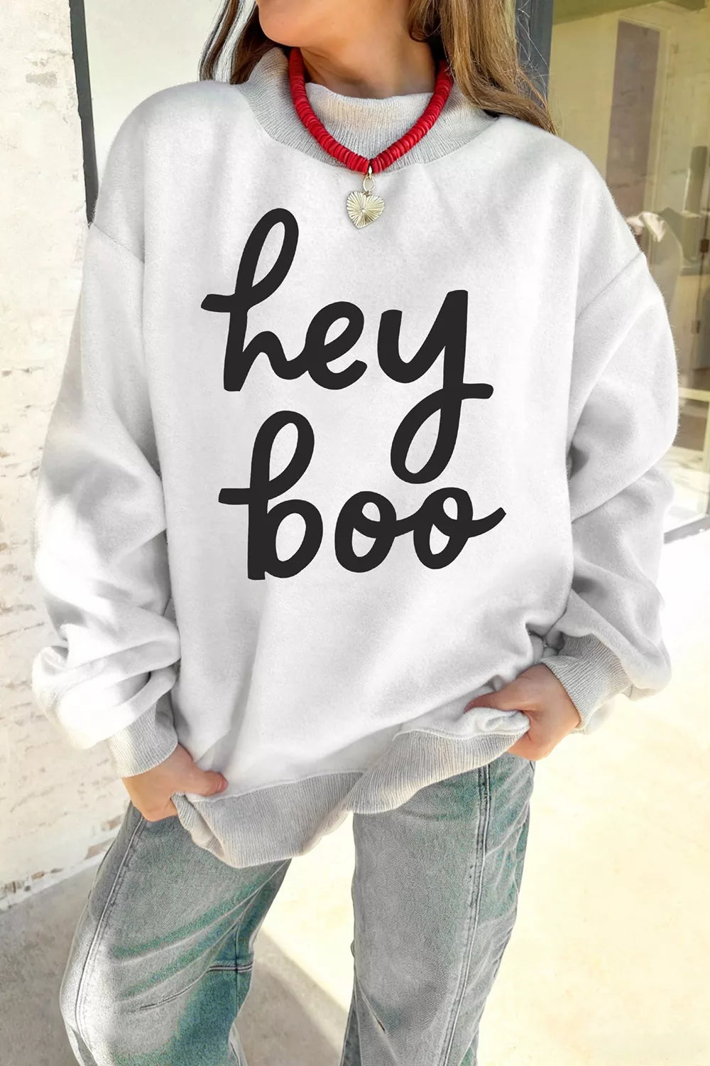 Reversible white mock neck tunic sweatshirt with "hey boo" black script and heart charm detail