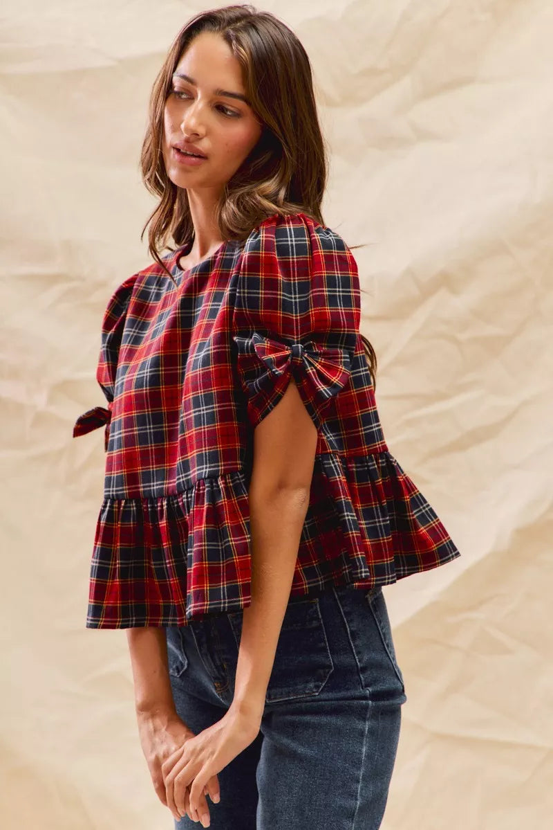 Red plaid peplum top with ribbon bow tie cuff and side sleeve detail