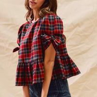 Red plaid peplum top with ribbon bow tie cuff and side sleeve detail