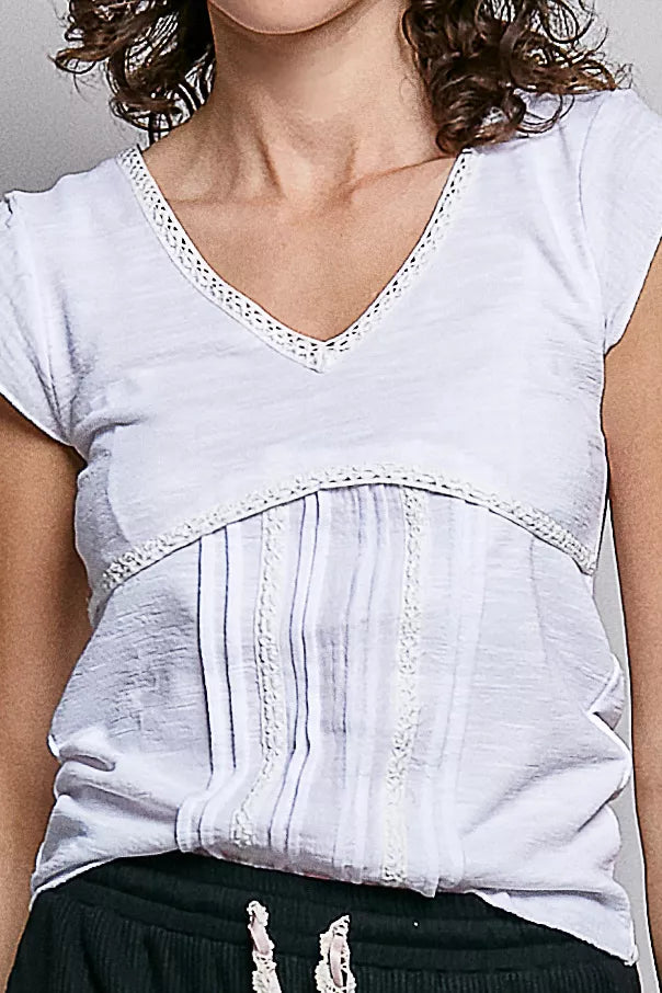 Off-white textured knit V-neck top close-up with lace-trim edge at neckline