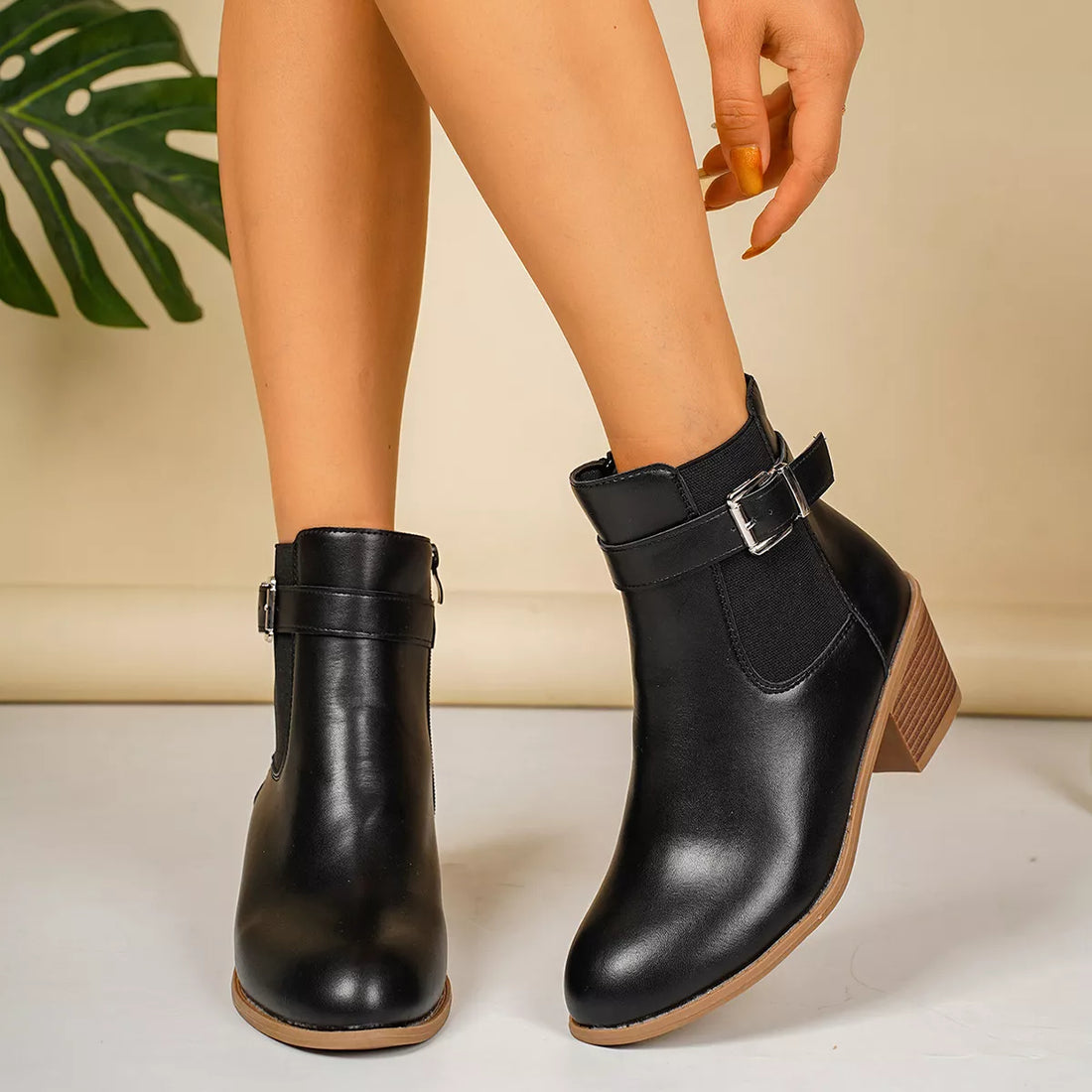 Point-toe block heel boots in black with side zip and buckle ankle strap