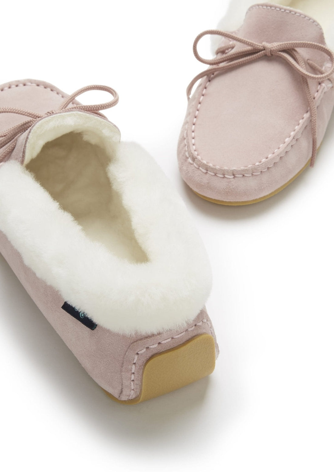 Pink suede slipper detail showing plush lining and tan heel sole