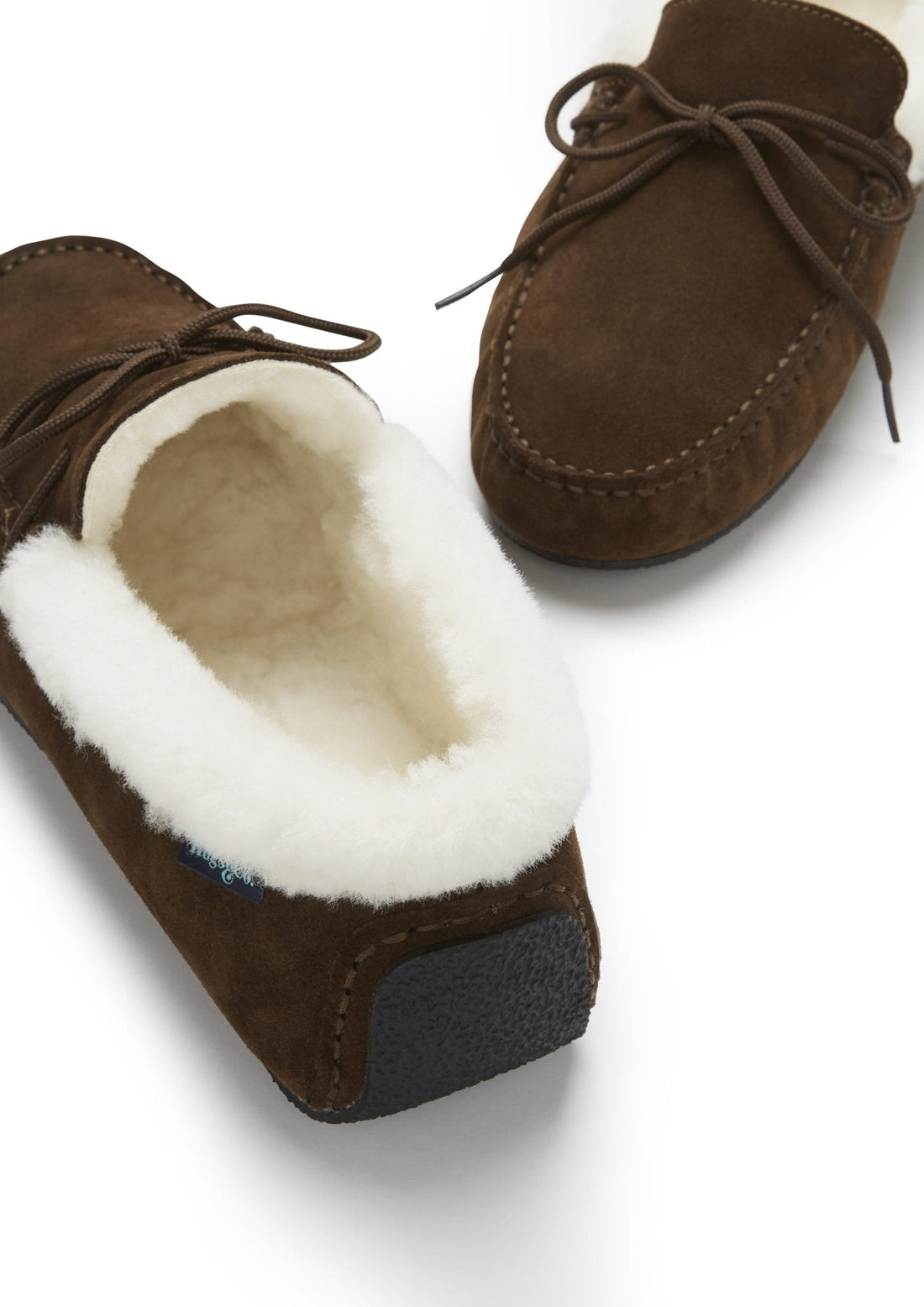 Brown suede slipper with a plush sheepskin opening and textured heel sole