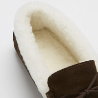Close-up of the cream sheepskin lining and brown suede upper of a slipper