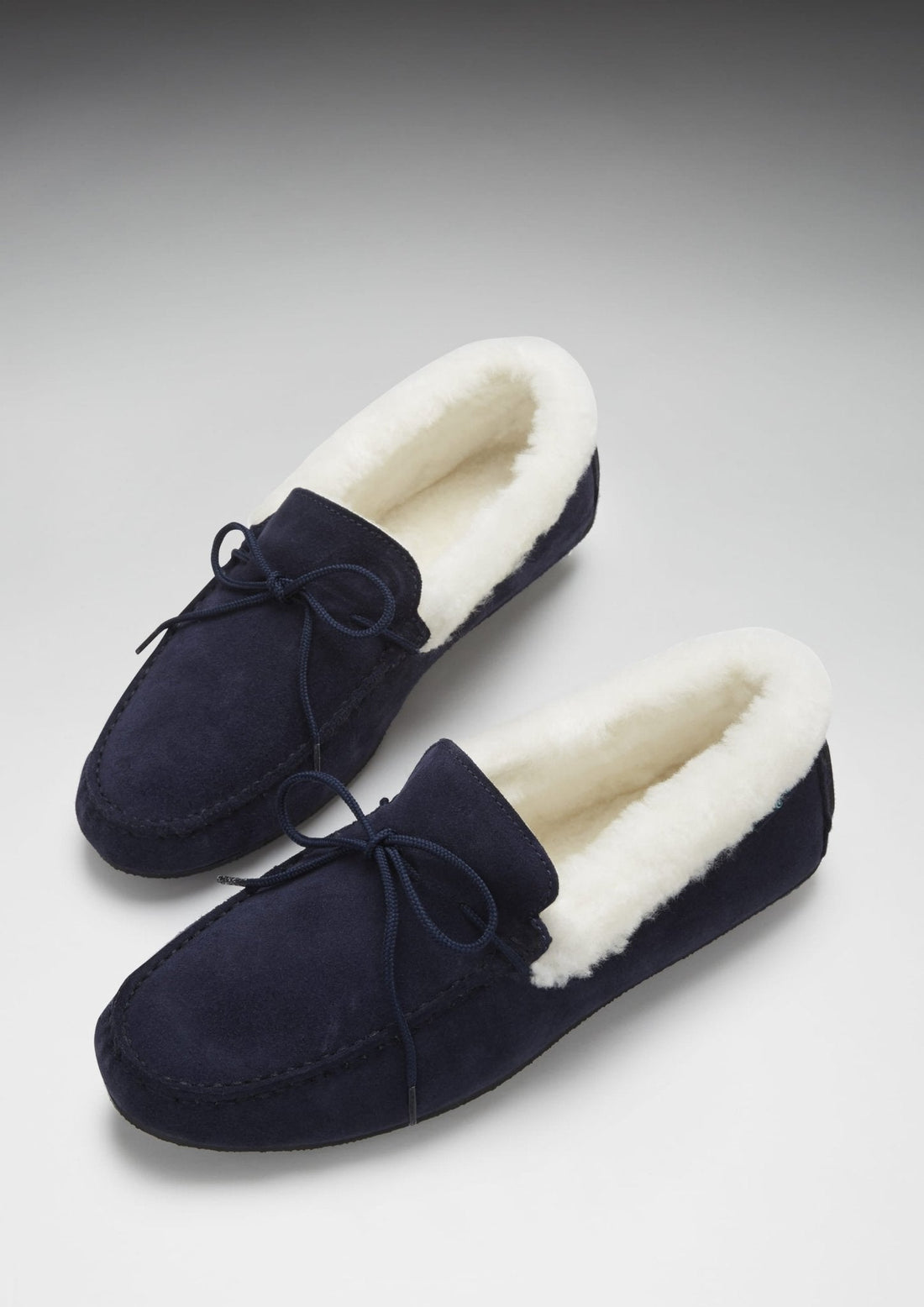 Pair of navy suede sheepskin slippers with cream lining and tie laces