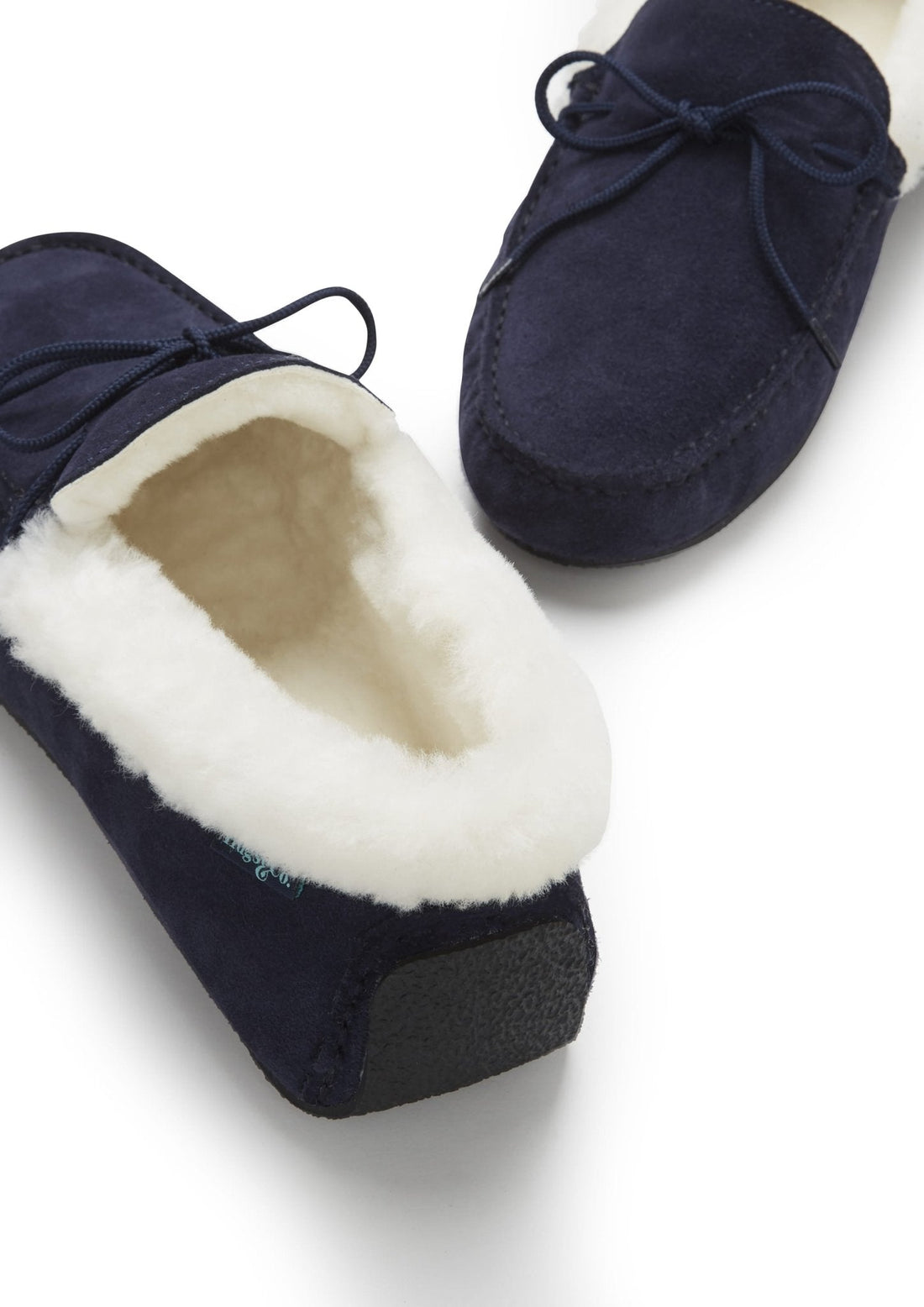 Navy suede slipper with visible cream sheepskin lining and textured sole