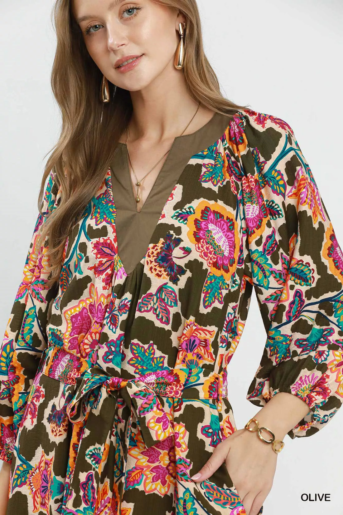 Close-up of belted midi dress: V-neck, long sleeves, dark olive floral print