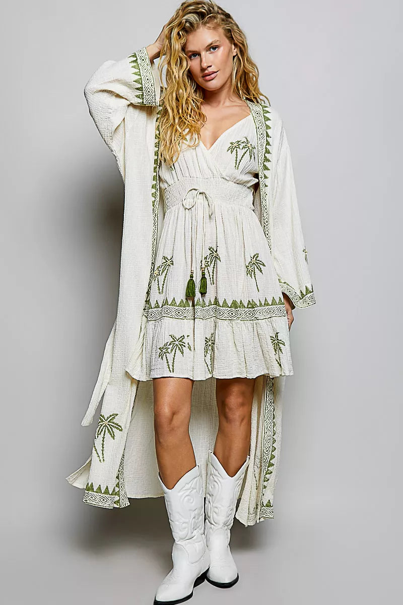 Natural palm tree print wrap dress with long draped sleeve overlay and tiered ruffle hem