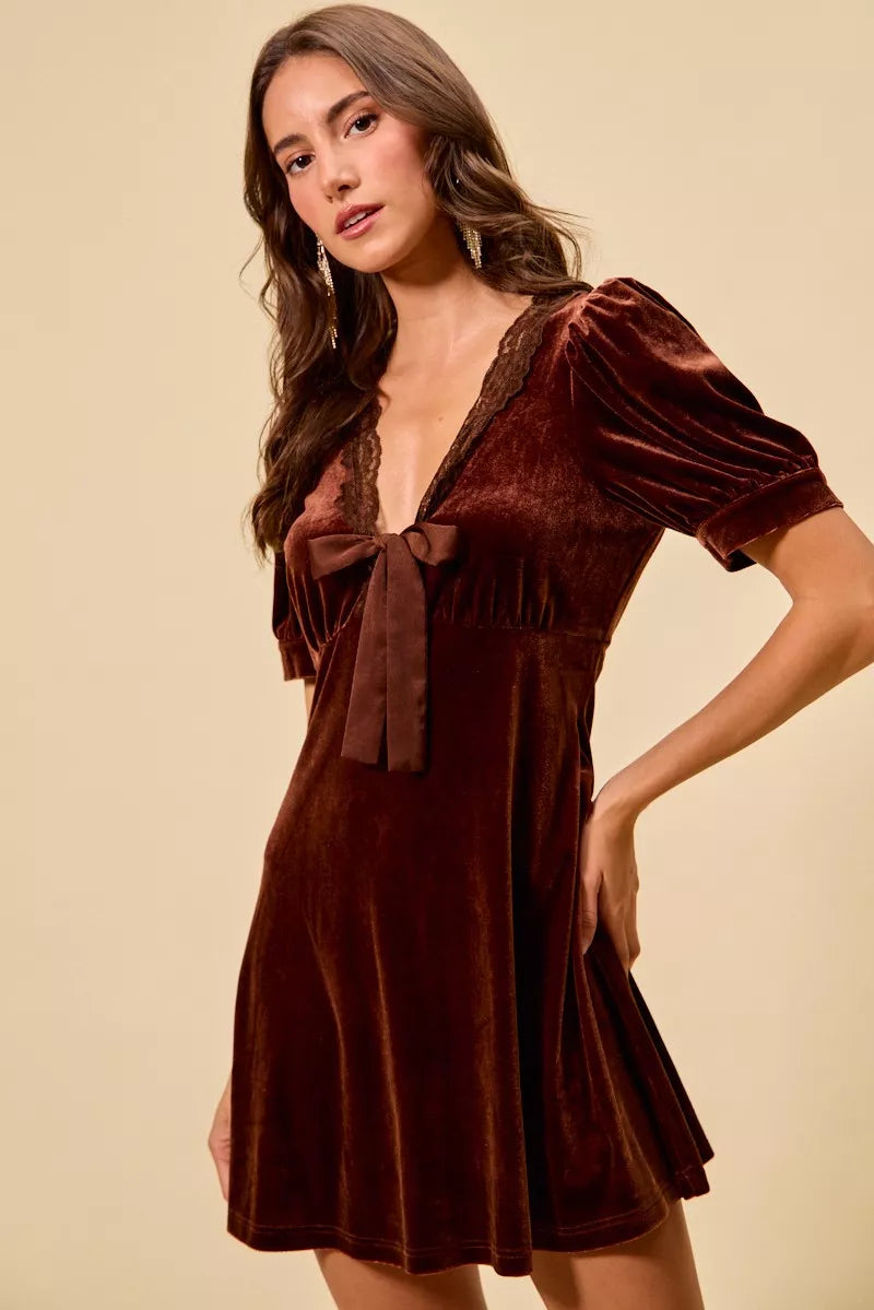 Burgundy velvet mini dress with lace-trim V-neck, tied bow, and gathered puff sleeves.