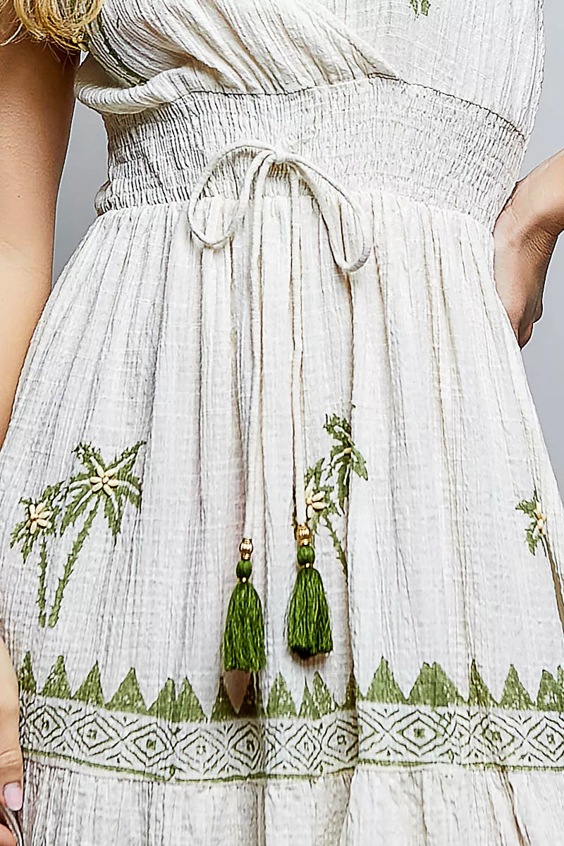 Natural palm tree print dress close-up: drawstring tie waist and ruffled skirt border