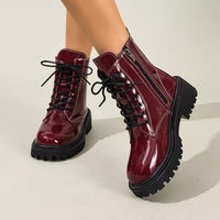 Burgundy patent lace-up block heel boots with black side panels and chunky tread sole