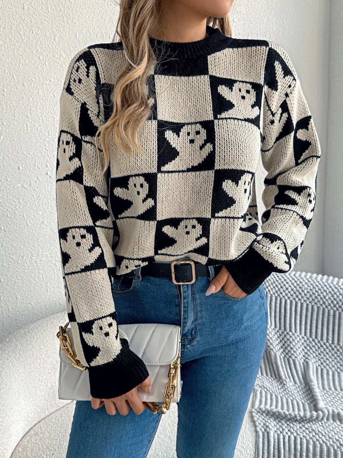 Ghost-pattern checkered round-neck sweater in black and cream, long sleeves.