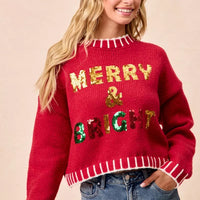 Red crewneck sweater with “Merry & Bright” sequin design and striped hem and cuffs