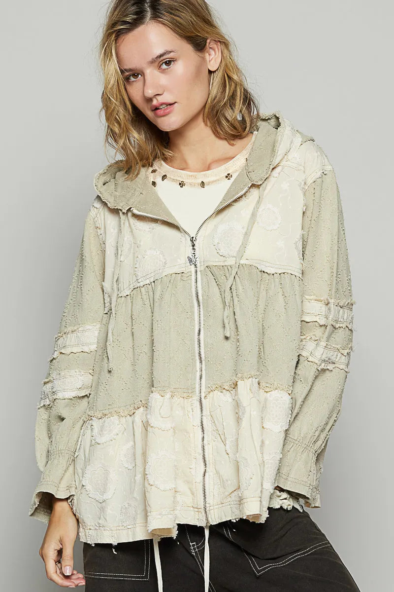 Beige hooded zip jacket with tiered color-block panels and raw, frayed edges