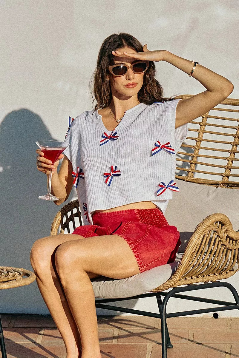 Off-white dolman sweater top with V-neck and red-white-blue ribbon bow appliques
