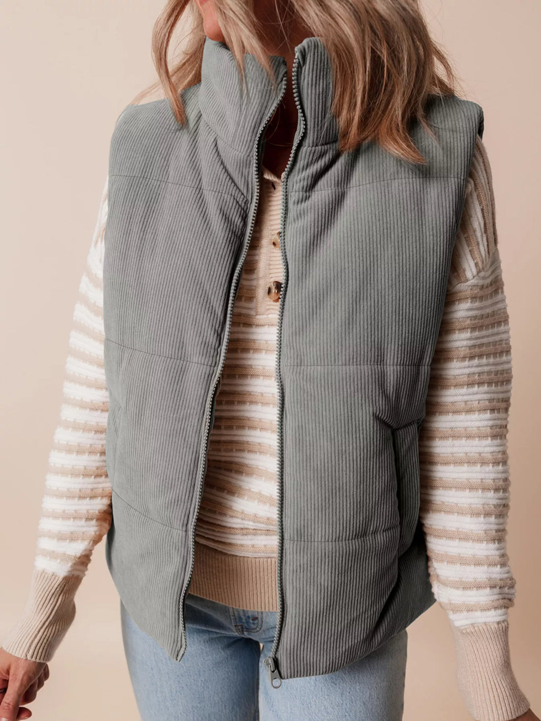 Gray corduroy puffer vest with stand collar, zip front, and chest opening detail.