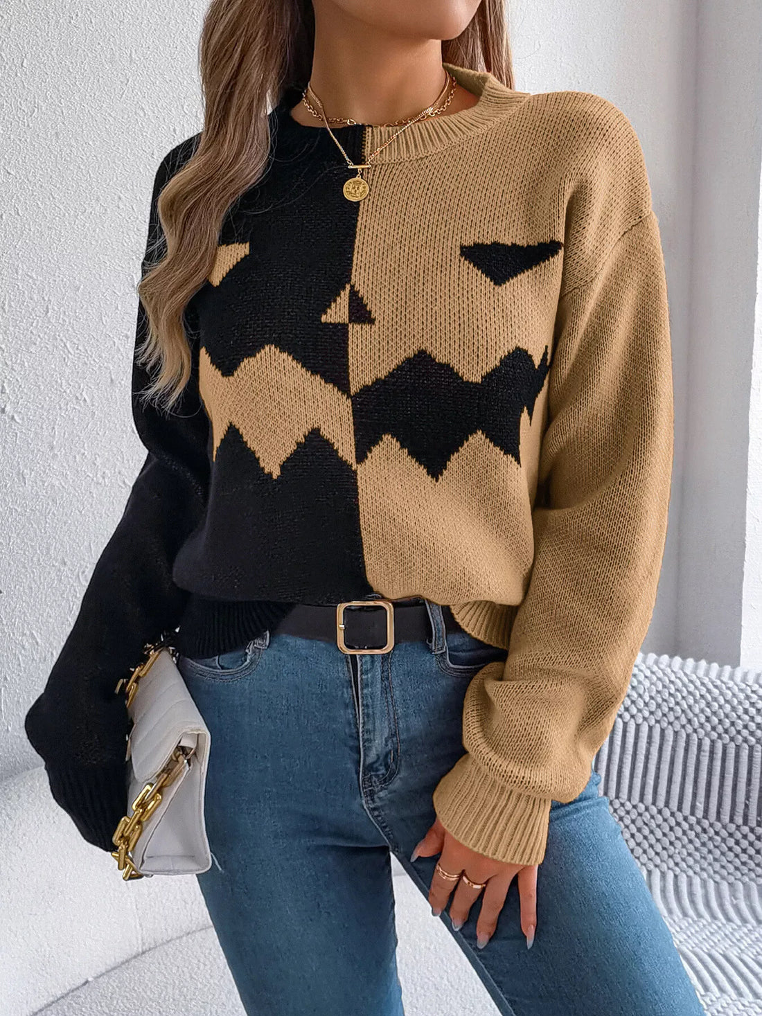 Two-tone knit sweater with pumpkin-face graphic, camel and black, button placket.