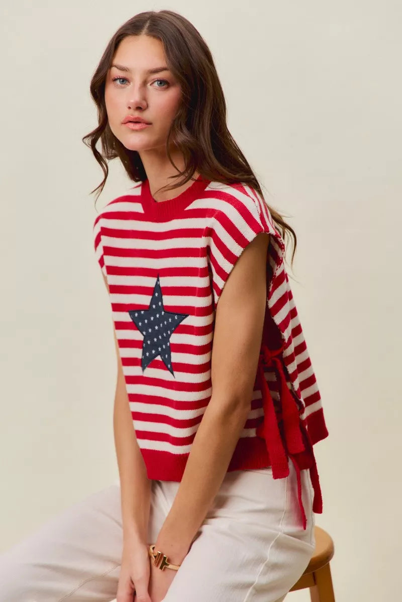 Red and ivory striped sleeveless vest top with navy star patch and draped side tie
