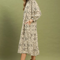 Beige botanical-print tiered midi dress shown in side view with long sleeves