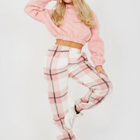 Light pink plaid joggers with elastic waist and drawstring ties.