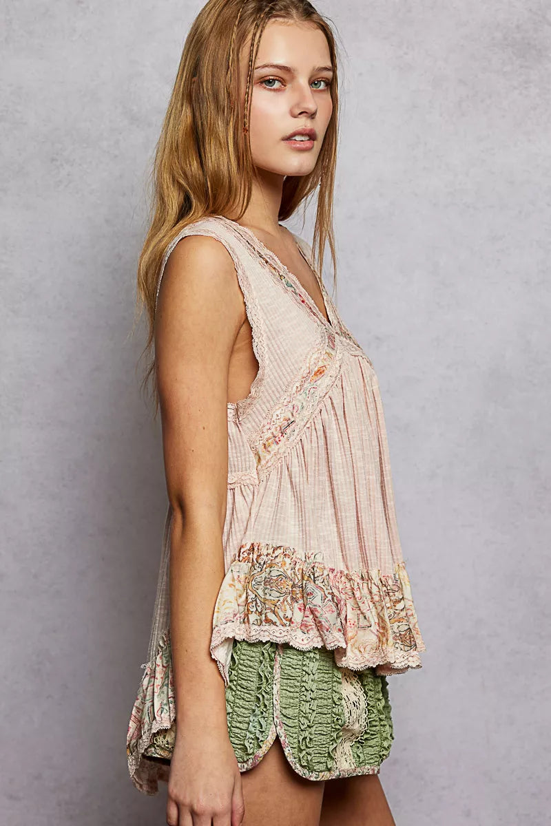 Pale pink lace-trim sleeveless peplum top with floral ruffled hem, side view