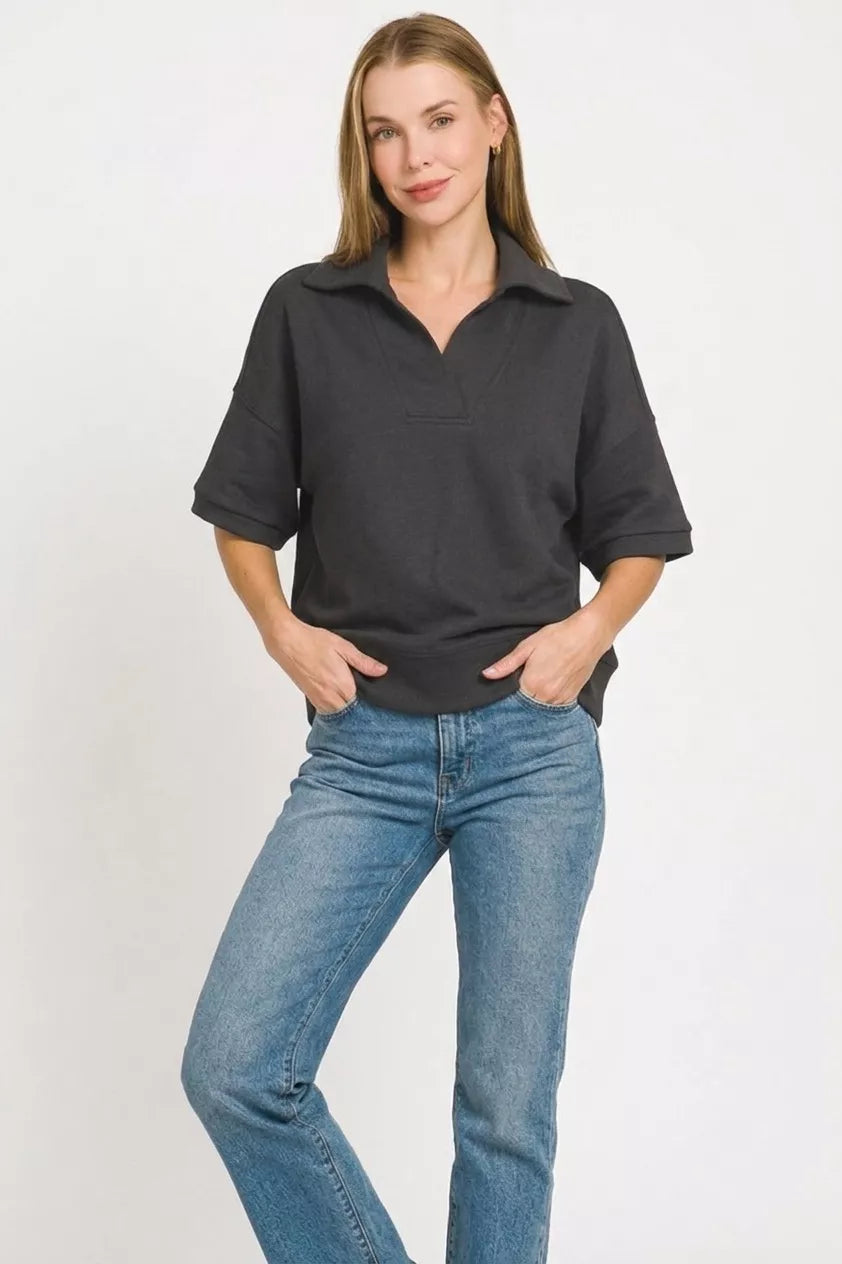 Black collared short-sleeve pullover with half-zip placket and straight hem