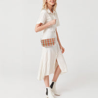 Plaid shoulder bag worn with white strap and gold chain, front flap