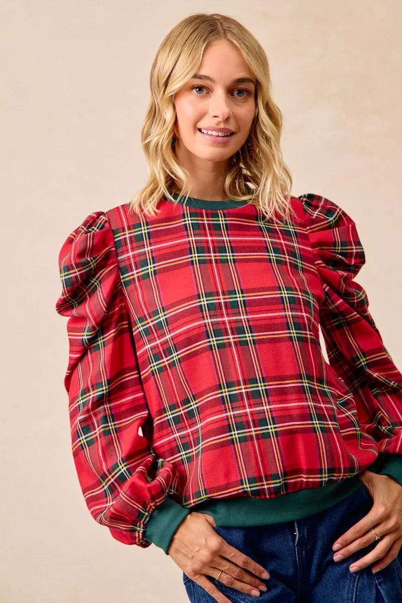 Red plaid blouse with exaggerated shoulders, puff sleeves, and green ribbed trim