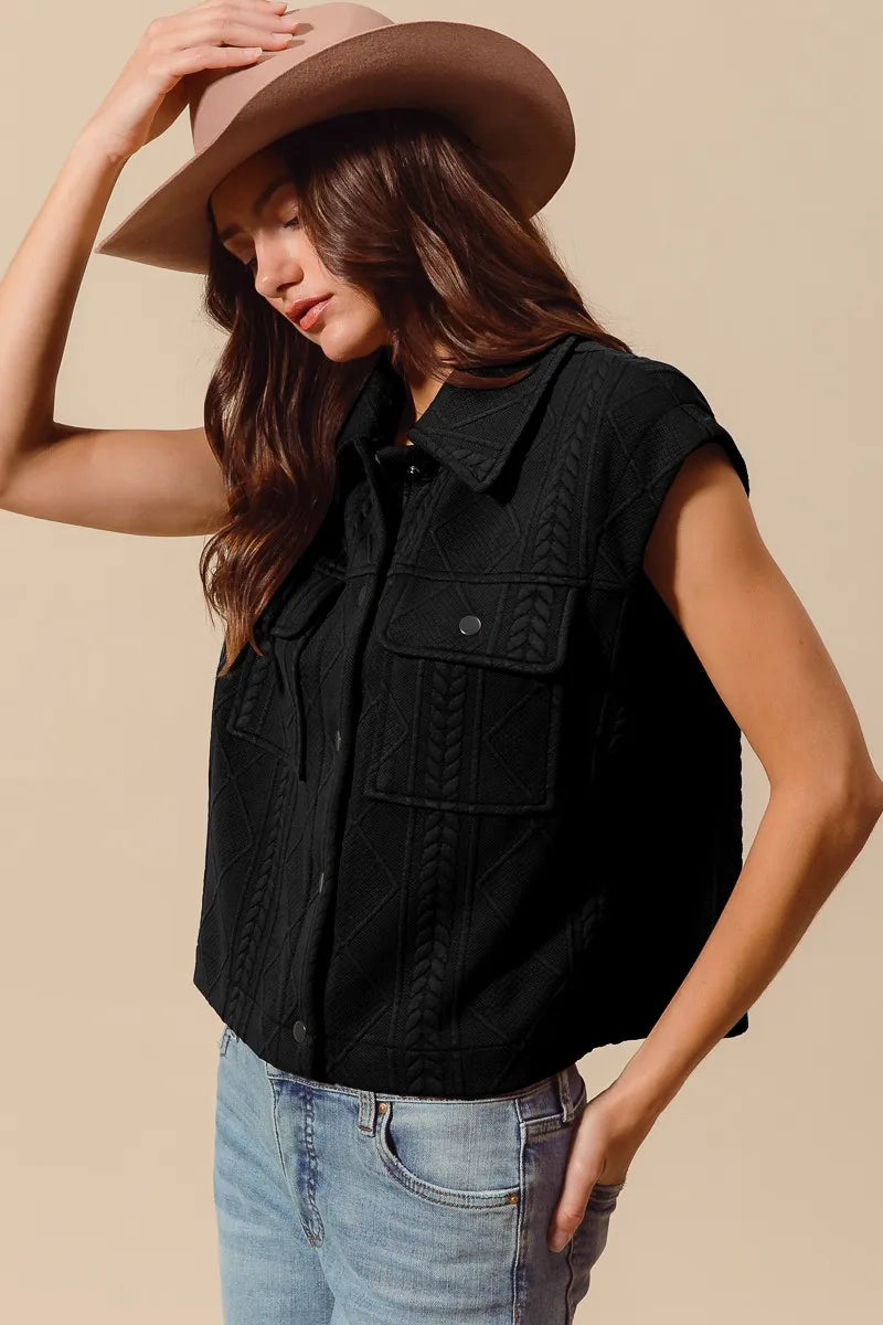 Black knit button-up vest with cable-quilt texture and flap chest pockets