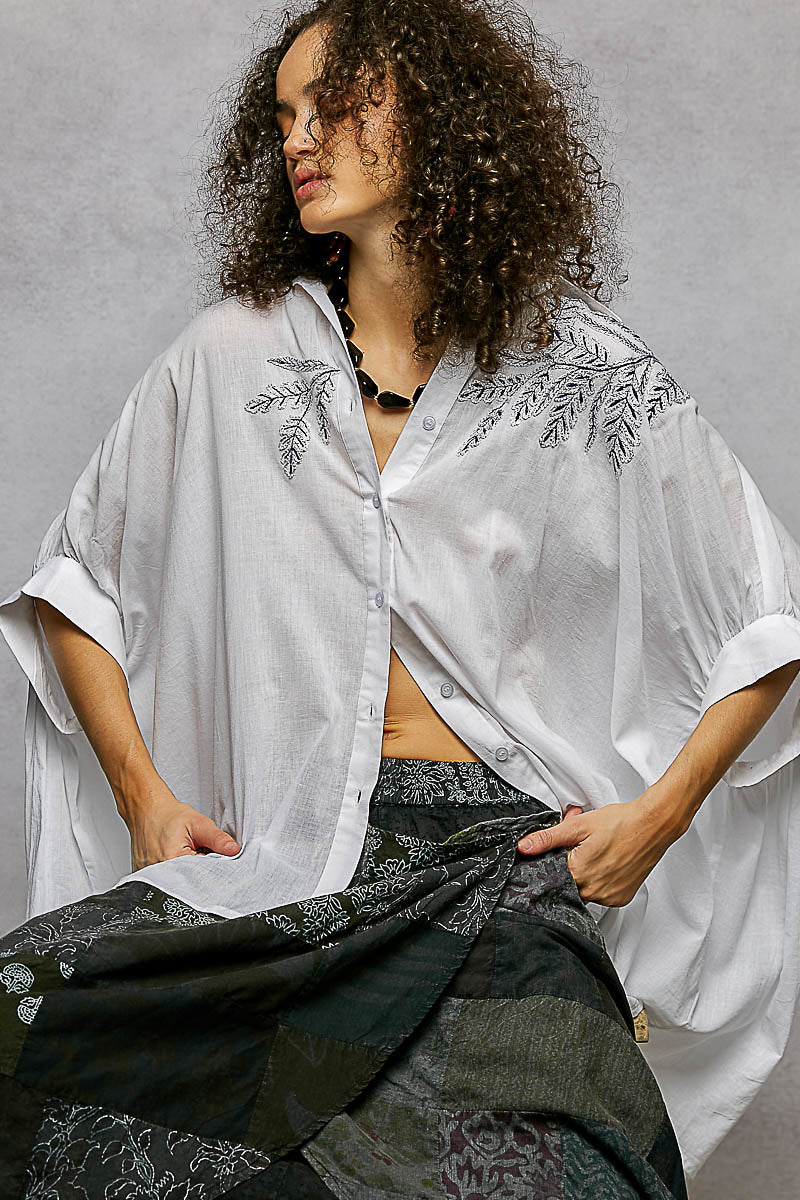 Ivory embroidered floral button-front shirt with open V-neck and flowing high-low hem