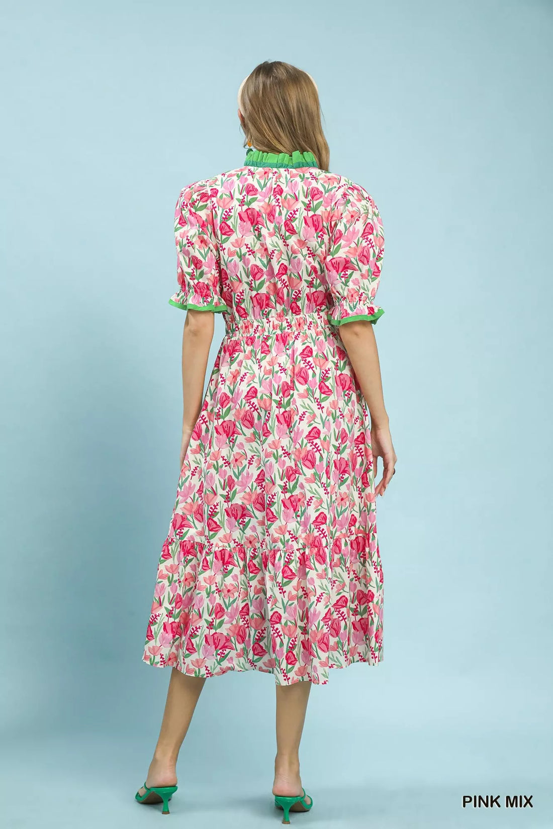 Back view of floral tiered midi dress in pink mix with puff sleeves and green trim