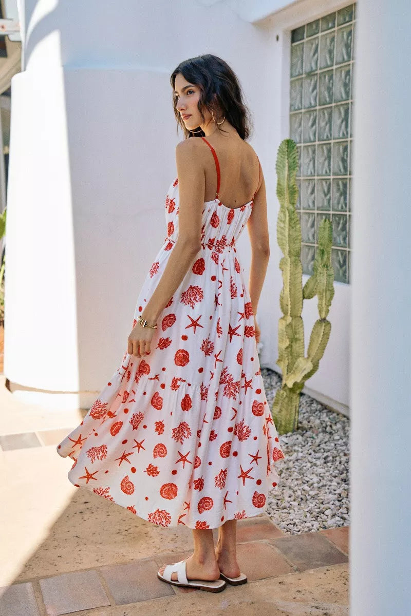 Back view of red-and-white shell print tiered midi cami dress, belted waist, lined