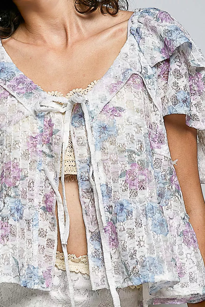 Close-up floral tie-front ruffle blouse with lace neckline and tassel trim, off-white