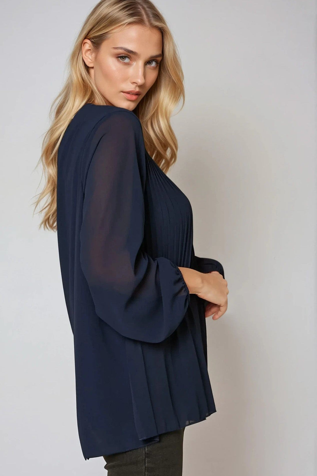 Navy long-sleeve pleated blouse, side view with billowy sleeves
