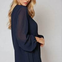 Navy long-sleeve pleated blouse, side view with billowy sleeves