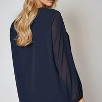 Navy long-sleeve pleated blouse, back/side view with gathered sleeves