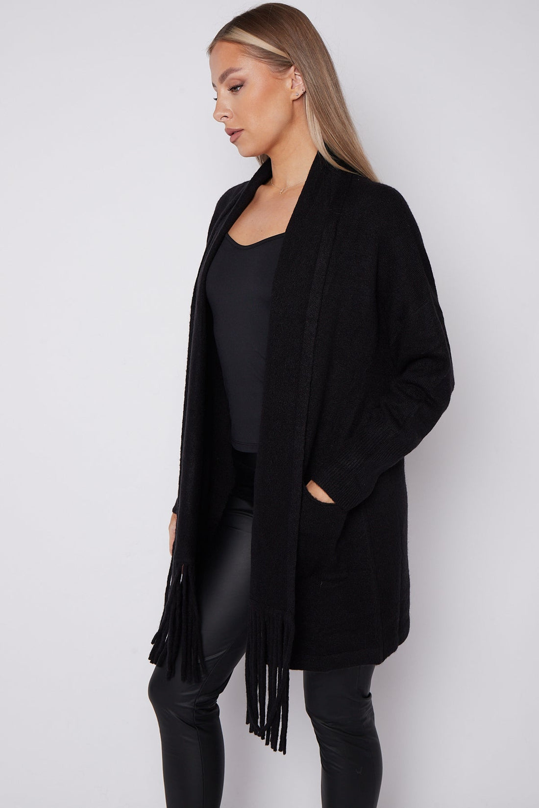 Black fringed shawl-collar cardigan with open front and tassel-trimmed hem