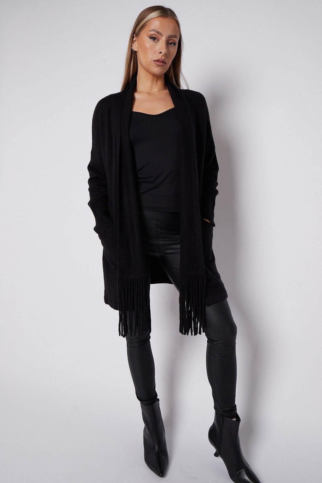 Black fringed cardigan with shawl collar, open front, and long tassel trim