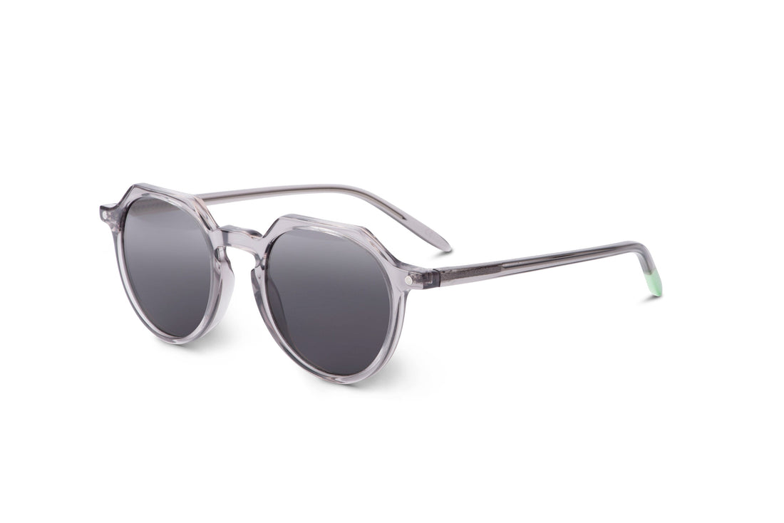Round sunglasses with transparent gray frame, dark lenses, side profile