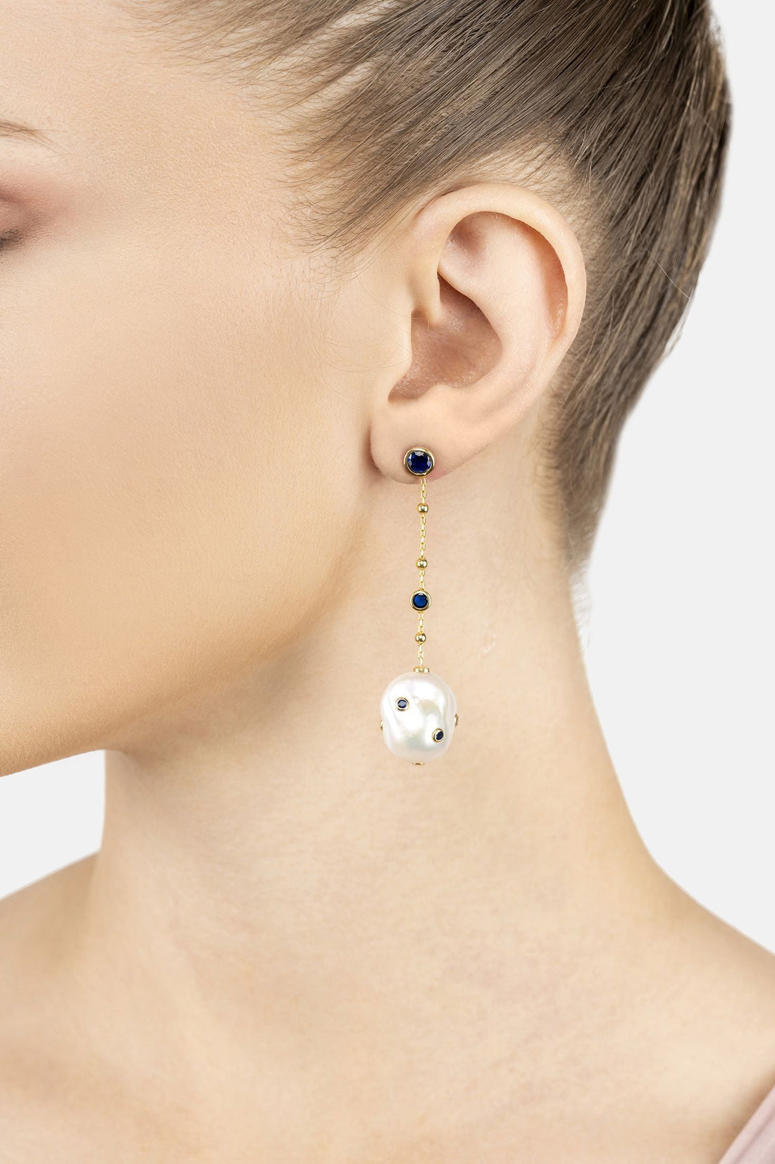 Gold-tone drop earrings with blue stones, pearl chain, and white baroque pearl charm