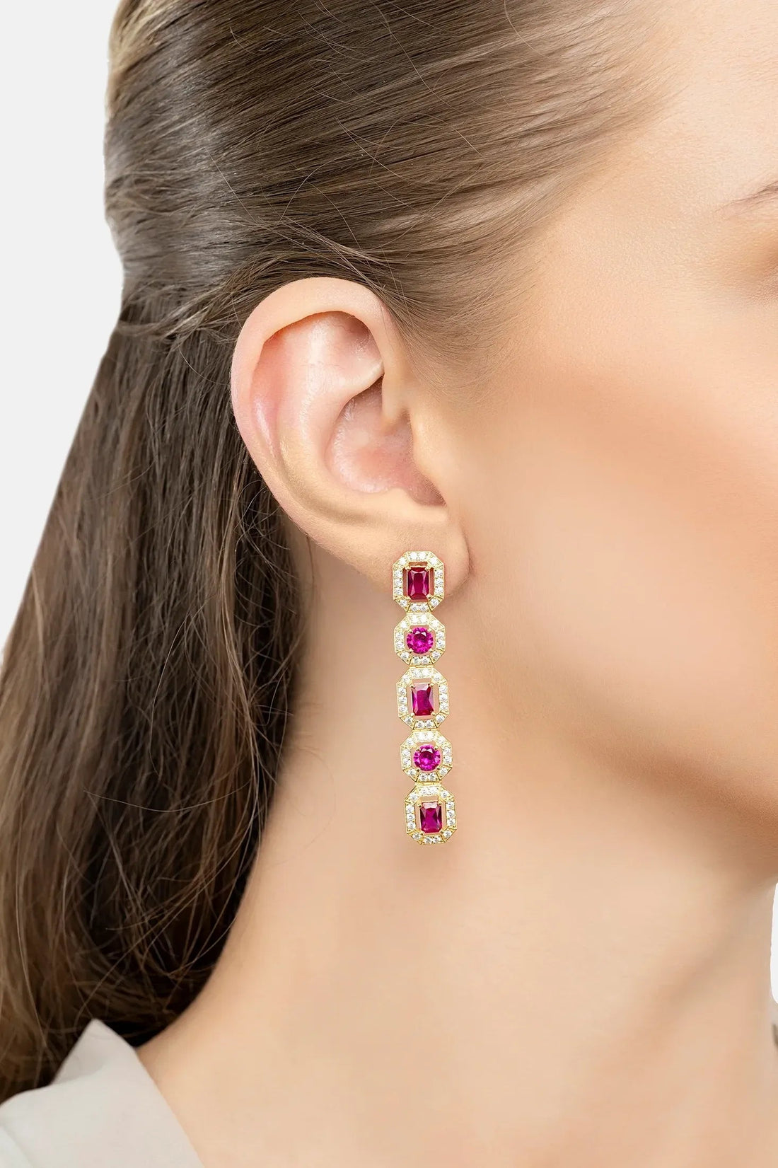 Gold-tone ruby gemstone drop earrings, five ruby-colored stones on ear